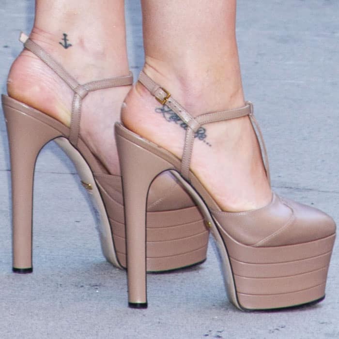 Her Gucci “Angel” platform pumps in glossy beige leather added towering height and a retro-glam finish to her look