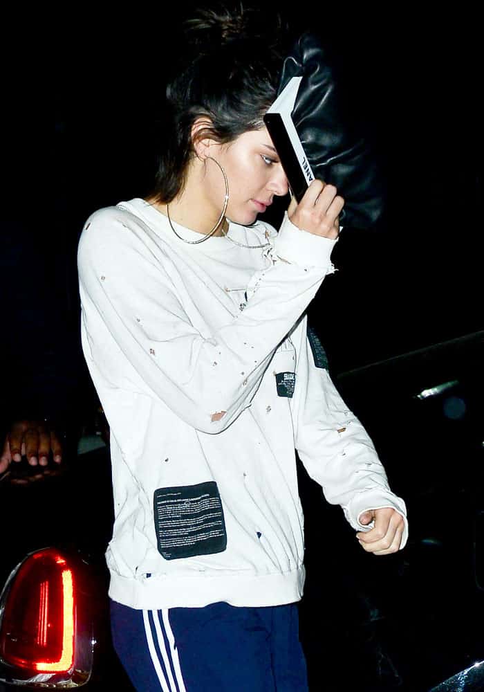 Kendall shields her face from the cameras behind a Chanel purse