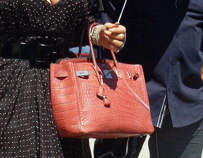 The reddish-brown crocodile Hermès Birkin 30 introduced warmth and texture to the outfit, standing in sharp contrast to the all-black ensemble while remaining the look's unmistakable focal accessory