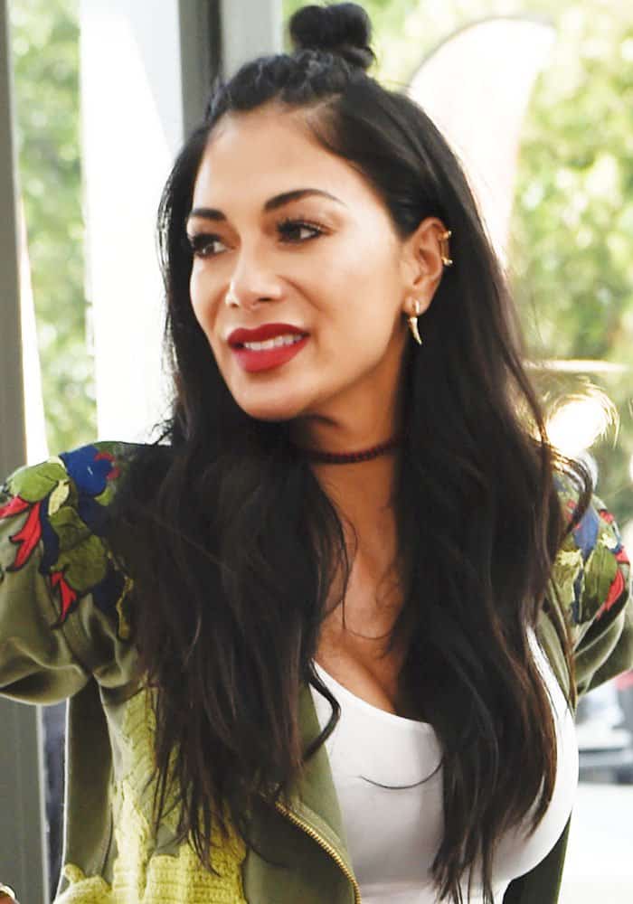 Nicole Scherzinger keeps her beauty look clean and modern, letting bold red lipstick and a relaxed half-up hairstyle balance the casual outfit beneath