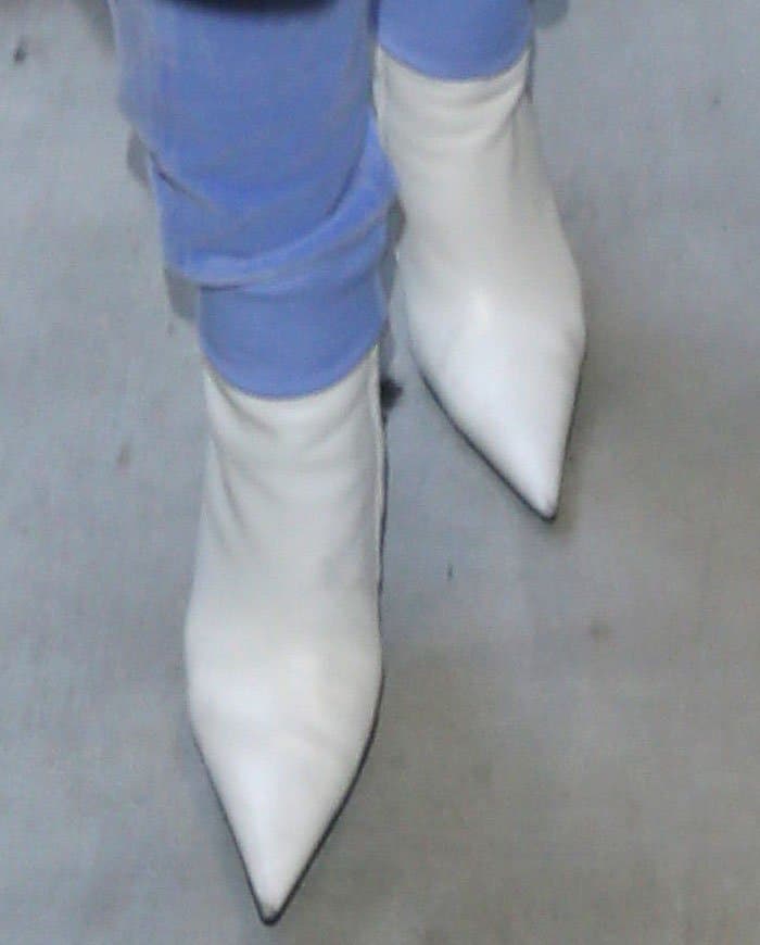 Rihanna completes her travel look with sleek white Balenciaga pointed-toe ankle boots