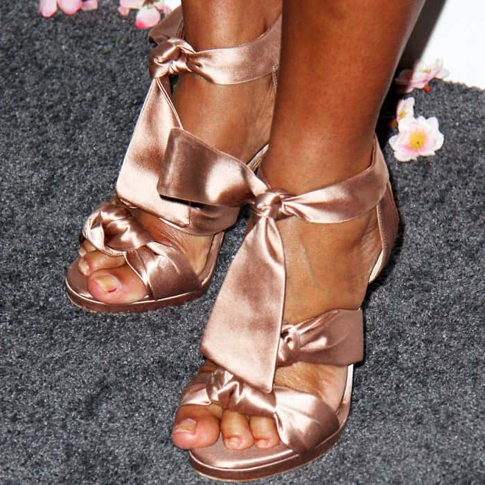 Tracee Ellis Ross steps out in blush satin Jimmy Choo “Kris” sandals featuring voluminous knotted straps that wrap elegantly around the ankle