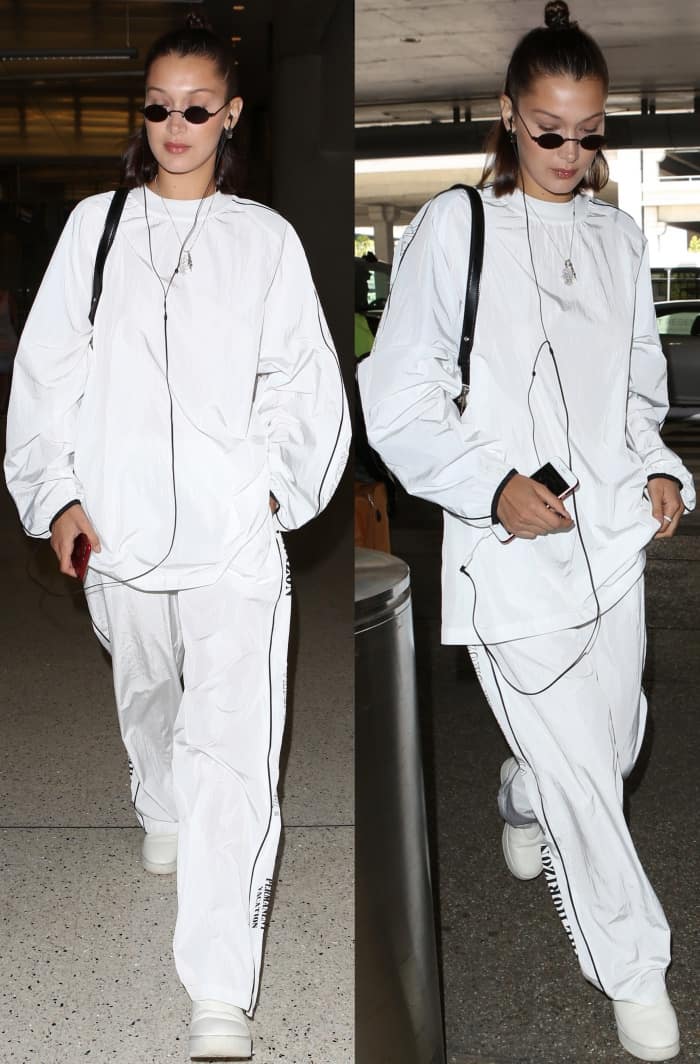 Bella Hadid was spotted at LAX Airport on June 21, 2017, wearing a Hyein Seo tracksuit with Celine pull-on sneakers, Roberi Fraud sunglasses, and a Versus Versace buckle clutch