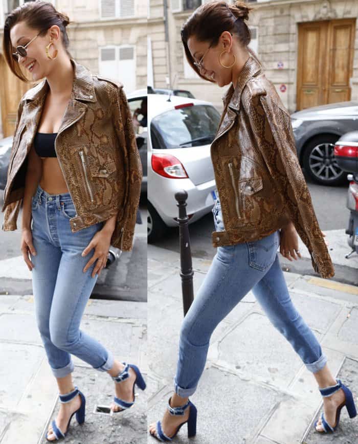 Bella Hadid wearing a snakeskin motorcycle jacket, black Dior bandeau top, Re/Done jeans, and Schutz "Janessa" denim sandals in Paris