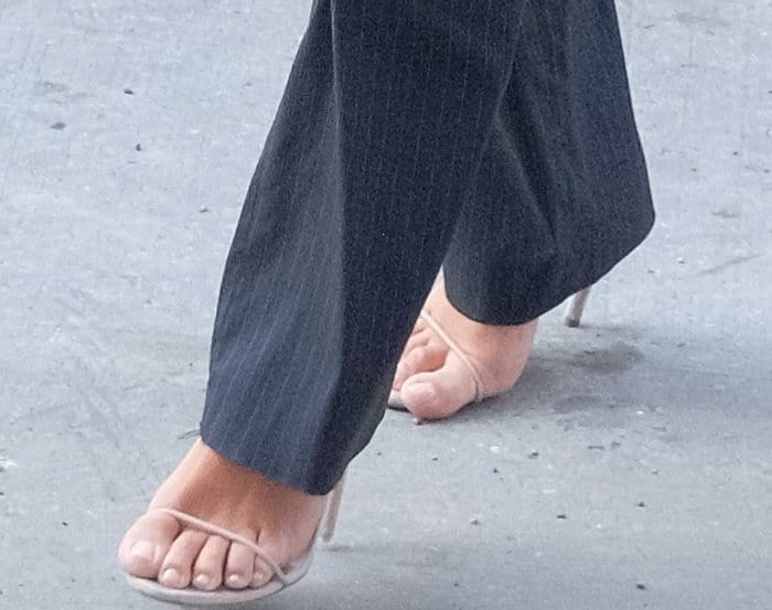 Kim Kardashian embraces the barely-there sandal trend in minimalist nude heels, featuring ultra-thin toe straps, delicate stiletto heels, and a clean, understated silhouette