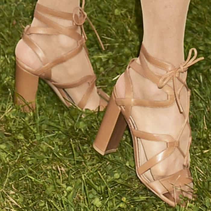 Gianvito Rossi’s gladiator-inspired sandals featured slim leather straps, lace-up ankle ties, and chunky block heels that balanced elegance with stability on the grass