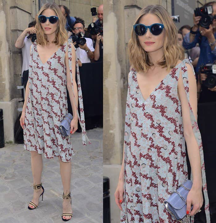 Olivia Palermo embraces effortless summer elegance in a flowing printed dress with tie-shoulder details, gold-accented heels, oversized sunglasses, and a studded Valentino Rockstud clutch