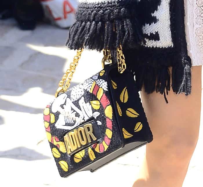 Jennifer Lawrence accessorizes with an eye-catching embroidered Dior J’Adior flap bag featuring bold yellow leaf motifs, tribal patterns, and gold hardware