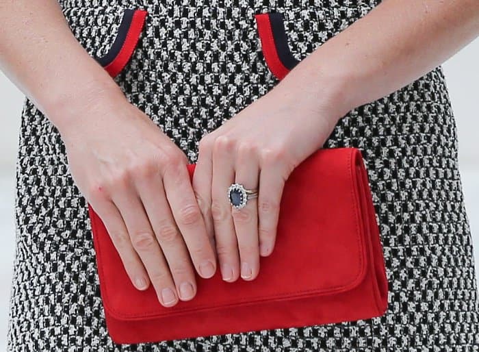 Completing her look, Kate coordinated the red trim of her dress with a vibrant Emmy London clutch, all while showcasing her iconic sapphire and diamond engagement ring
