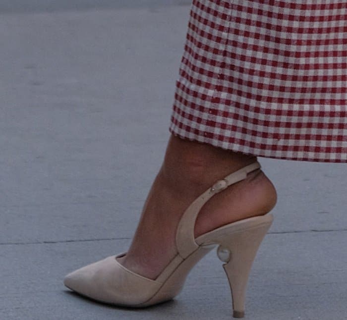 Laura Harrier completes her gingham look with nude slingback heels featuring a sculpted cut-out detail, subtly blending with her skin tone to create the illusion of longer legs