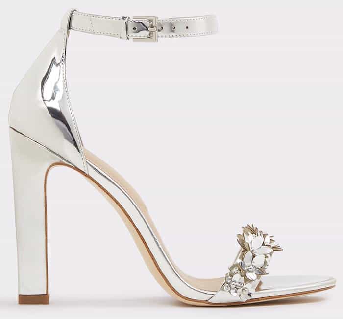 Sleek and reflective, Aldo’s “Milaa” ankle-strap sandals combine a block heel with metallic floral embellishments for a polished yet wearable statement finish