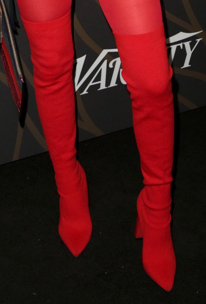 Jenna Ortega’s pointed red thigh-high boots sharpen her monochrome look, using stretch fabric and a sleek toe to elongate the leg from every angle