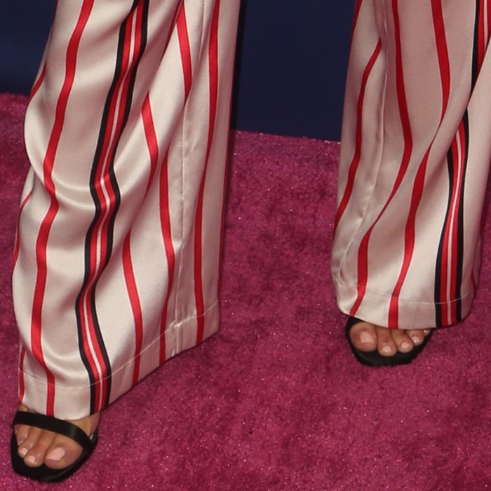 In a later appearance, striped satin trousers skim the floor, allowing just a glimpse of black open-toe sandals beneath the hem