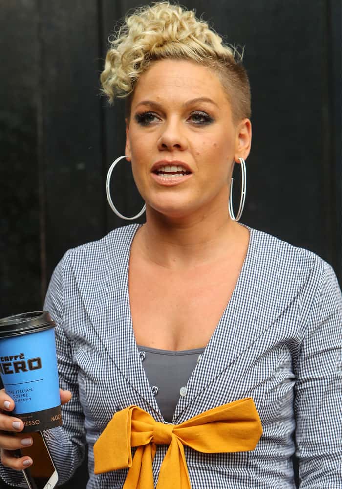 Pink flashed her signature confidence outside Absolute Radio Studios, pairing oversized hoops with a playful bow-front jacket
