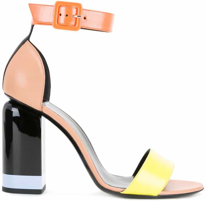 Pierre Hardy’s “Memphis” sandals feature bold color-block leather straps, a sculptural ankle buckle, and a high glossy block heel that grounds the playful palette with graphic precision