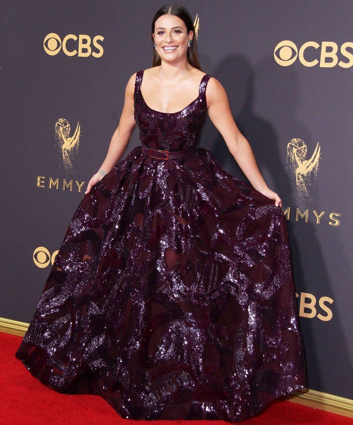 At the 2017 Emmys, Lea Michele brought her signature drama in a plum Elie Saab Fall 2017 gown with a shimmering pleated skirt and side pockets, though the floor-sweeping hemline concealed her high heels — a go-to choice for the petite 5ft 2in star who relies on stilettos to add height on the red carpet