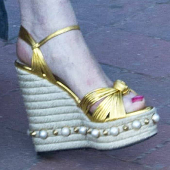 Lindsay Lohan steps out in statement-making Gucci “Barbette” espadrille wedge sandals, featuring gold knotted straps, a rope-wrapped platform, and pearl stud detailing