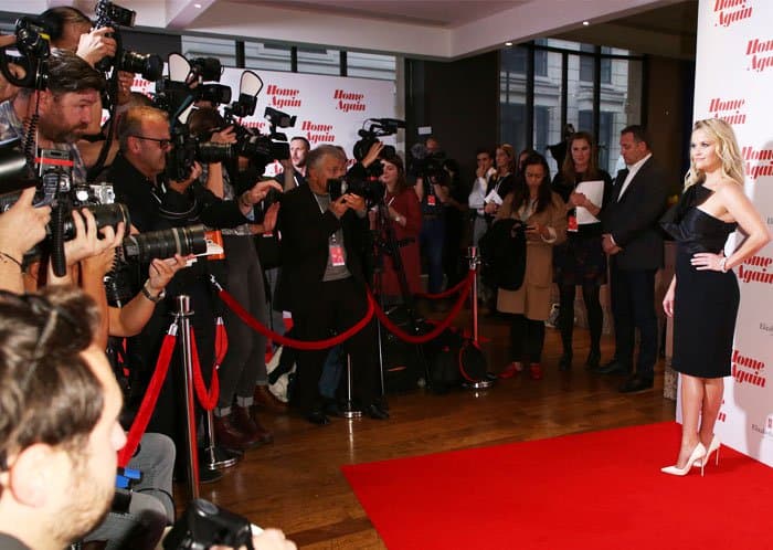 Photographers crowded the Home Again premiere as Reese Witherspoon posed in a monochrome look anchored by sharply pointed Christian Louboutin heels