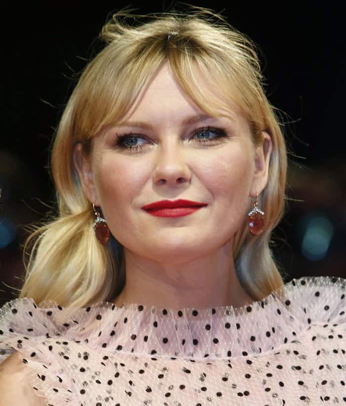 Kirsten Dunst complements her vintage Rodarte gown with soft waves, bold red lips, and vintage-inspired Irene Neuwirth earrings
