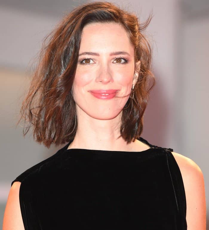 Rebecca Hall radiates effortless beauty with tousled waves, soft pink glossy lips, and subtle smoky eye makeup