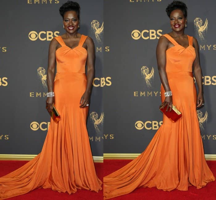Viola Davis lit up the red carpet in a custom tangerine Zac Posen gown, accessorized with a bold red-and-gold clutch, dazzling diamond cuff bracelet, and a radiant smile to match her vibrant look
