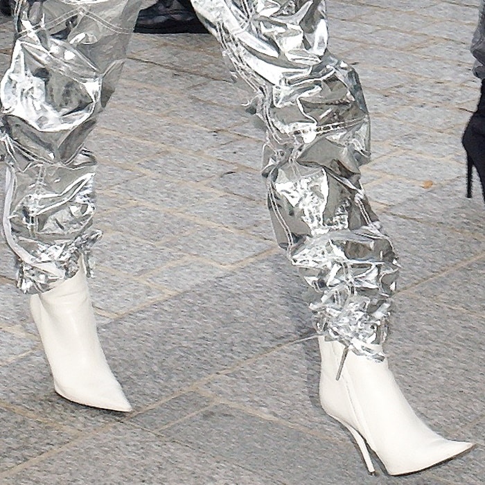 A close-up of Hailey Baldwin’s look reveals her sleek white Balenciaga “Knife” boots, which added a sharply tailored edge to her crinkled silver metallic pants during Paris Fashion Week