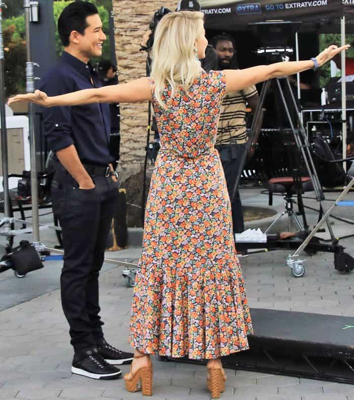 Julianne turns to greet the crowd, revealing the flowy, ruffled hem of her dress and the sculptural design of her Alchimia di Ballin heels from the back
