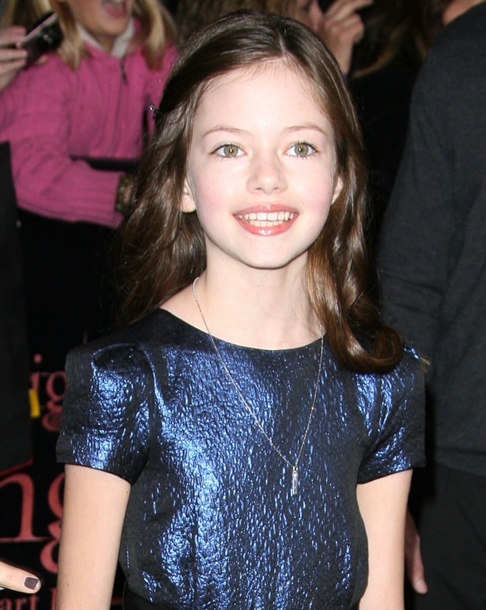A young Mackenzie Foy glows in a shimmering navy textured dress at the world premiere of The Twilight Saga: Breaking Dawn – Part 1 at Nokia Theatre L.A. Live on November 14, 2011