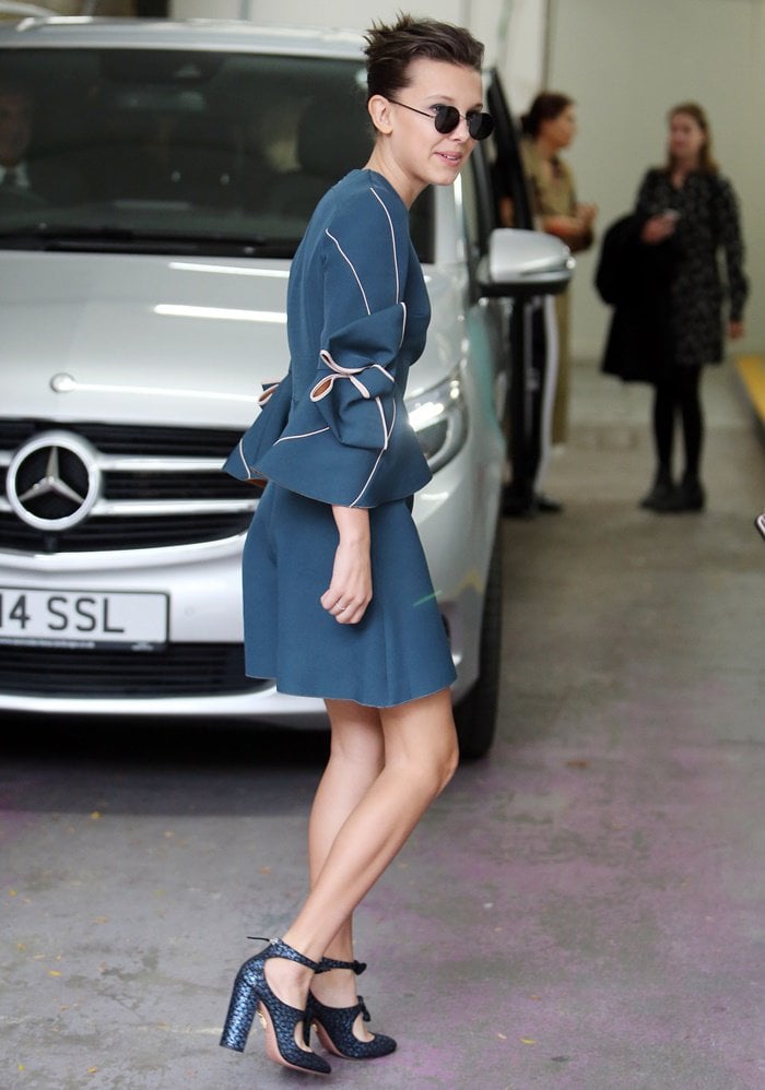 Millie Bobby Brown elevates her Roksanda stretch-crepe ‘Harlin’ dress with bold cutout ankle-strap heels for a polished, modern finish