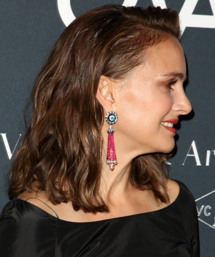Adding a vibrant pop to her dark ensemble, Natalie Portman styled her look with intricate pink beaded drop earrings featuring a colorful floral stud