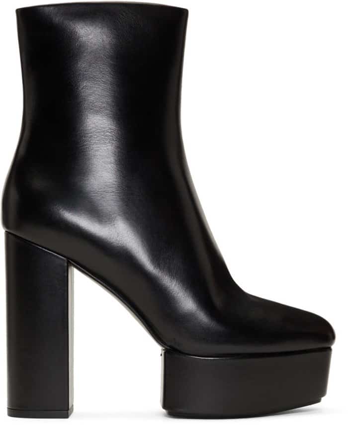 Alexander Wang “Cora” platform boots feature smooth black leather, a square toe, side zip closure, and a thick block heel with a covered platform—making them a stable, high-impact choice for grounding oversized or costume-driven looks