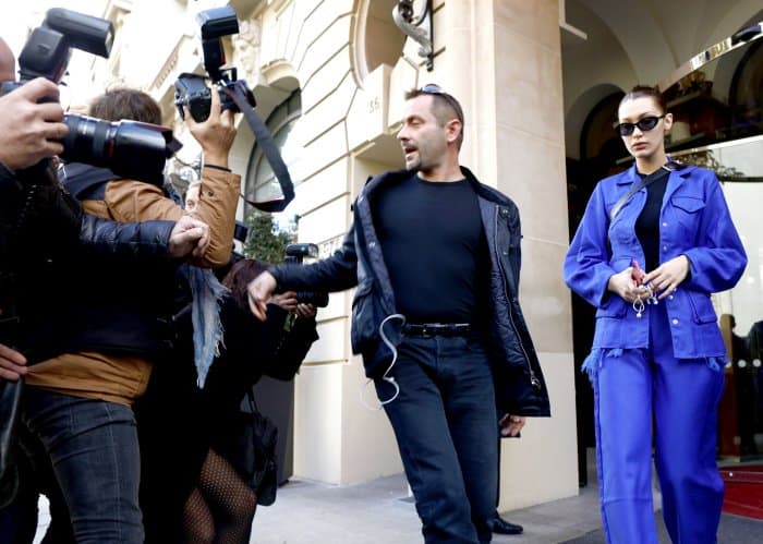 Bella Hadid exits Le Royal Monceau Hotel in Paris on October 3, 2017, in a bold blue ensemble and sunglasses, met by a crowd of eager photographers capturing her striking look