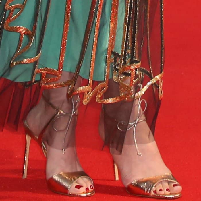Carey Mulligan completes her look with metallic gold Francesco Russo sandals, showcasing a chic red pedicure that adds a polished touch to her London Film Festival ensemble