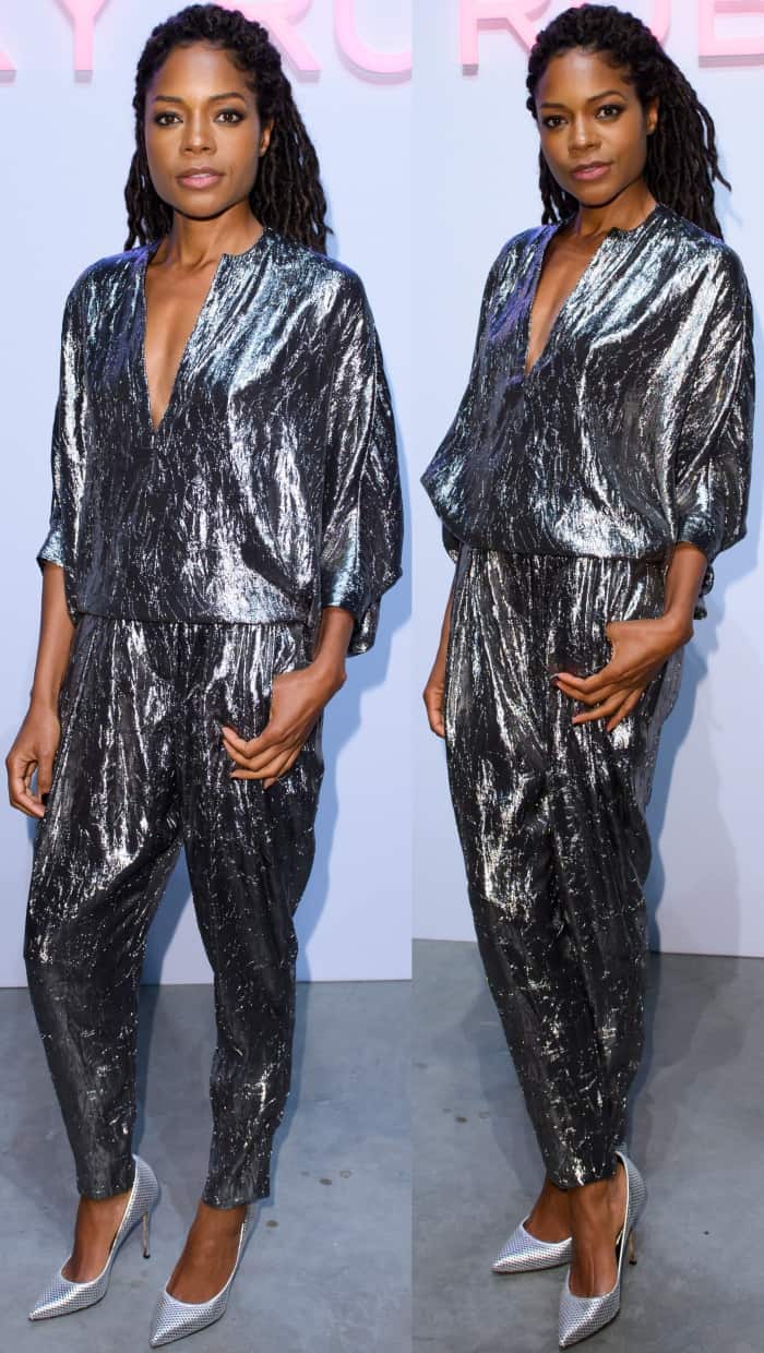 Naomie Harris dazzles in a shimmering silver Michael Kors ensemble, pairing a crushed silk-blend blouse with matching tapered pants and metallic pointy-toe heels for a bold, glamorous look