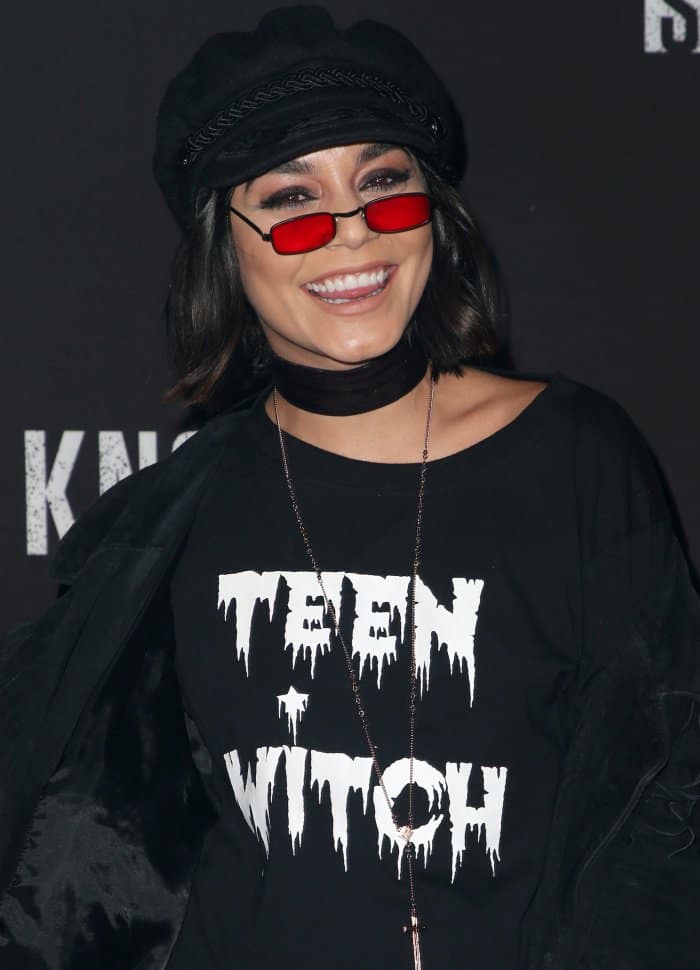 A close-up reveals the graphic “Teen Witch” tee and dark accessories that set the tone for the outfit’s edgy, costume-inspired theme
