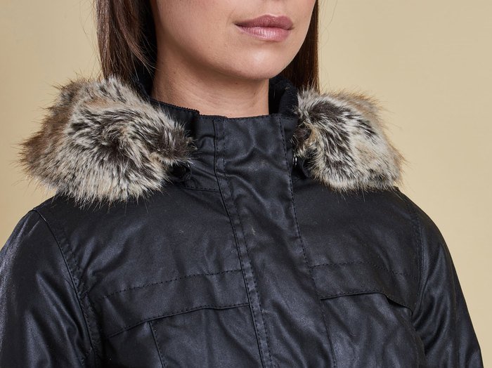 This genuine Barbour jacket features a luxurious faux fur trim with soft, multi-tonal fibers—a key indicator of the brand’s signature quality and attention to detail