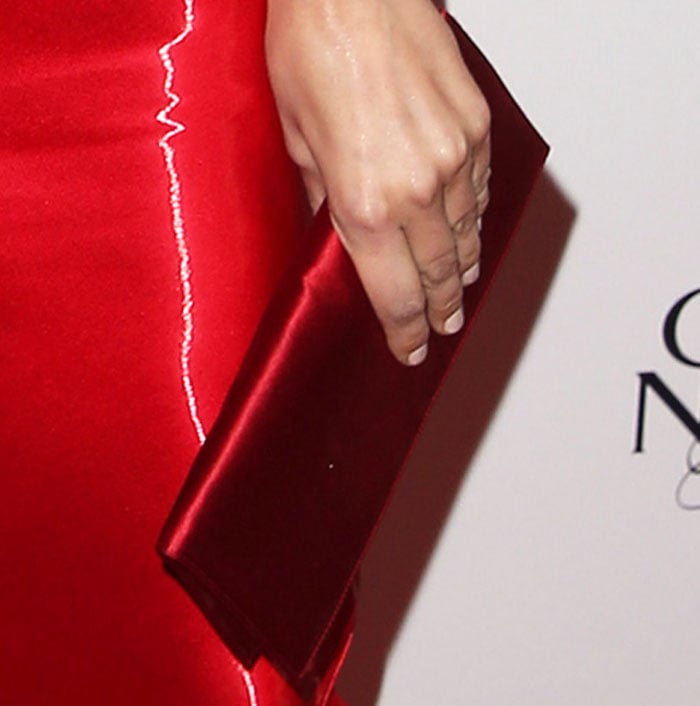 Camilla Belle's elegant red satin clutch provides a refined textural accent