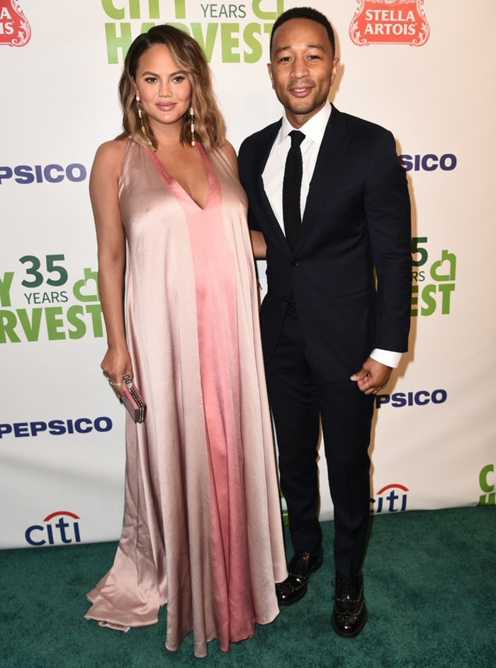 Chrissy Teigen completed her flowing Valentino gown with blush satin Giuseppe Zanotti “Mischa” heels, elevating the look with Lorraine Schwartz earrings, glittering Ofira rings, and a coordinating Judith Leiber clutch