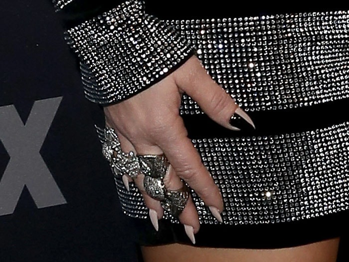 Fergie's signature edgy style shines through in the details, from the party of silver metal rings to her unique half-black and half-nude nails