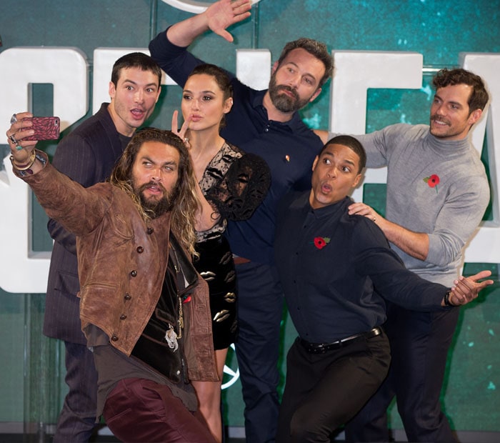 Jason Momoa, Ezra Miller, Gal Gadot, Ben Affleck, Ray Fisher, and Henry Cavill share a fun and playful moment while posing for a selfie at the Justice League photocall