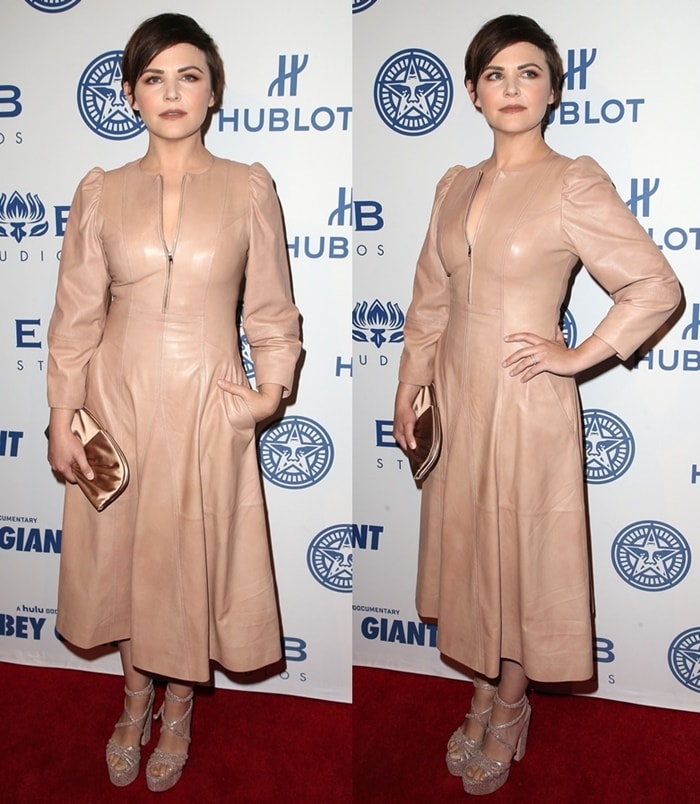 The actress poses on the red carpet, styling the minimalist leather dress with a metallic clutch and platform heels