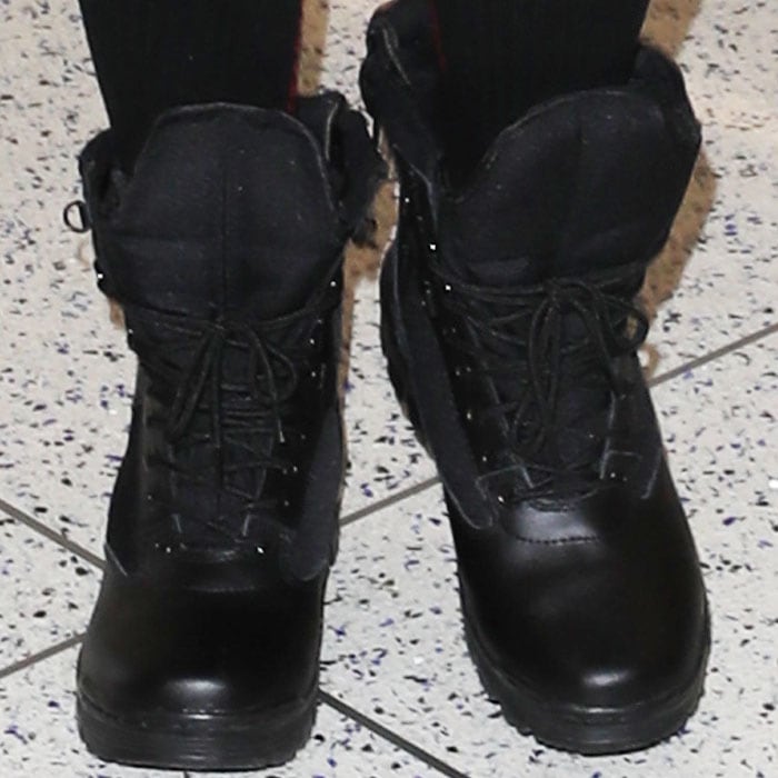 Khloé Kardashian showcases the enduring versatility of black combat boots as go-to travel footwear, perfectly blending comfort with a stylish edge for airport chic