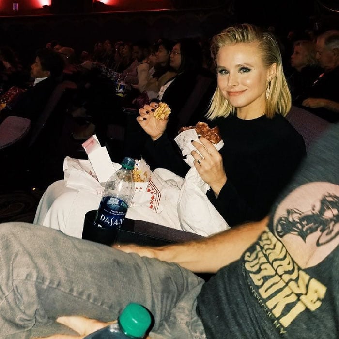 Kristen Bell, embodying the "bad mom" persona, happily snacks on movie theater favorites while attending the premiere