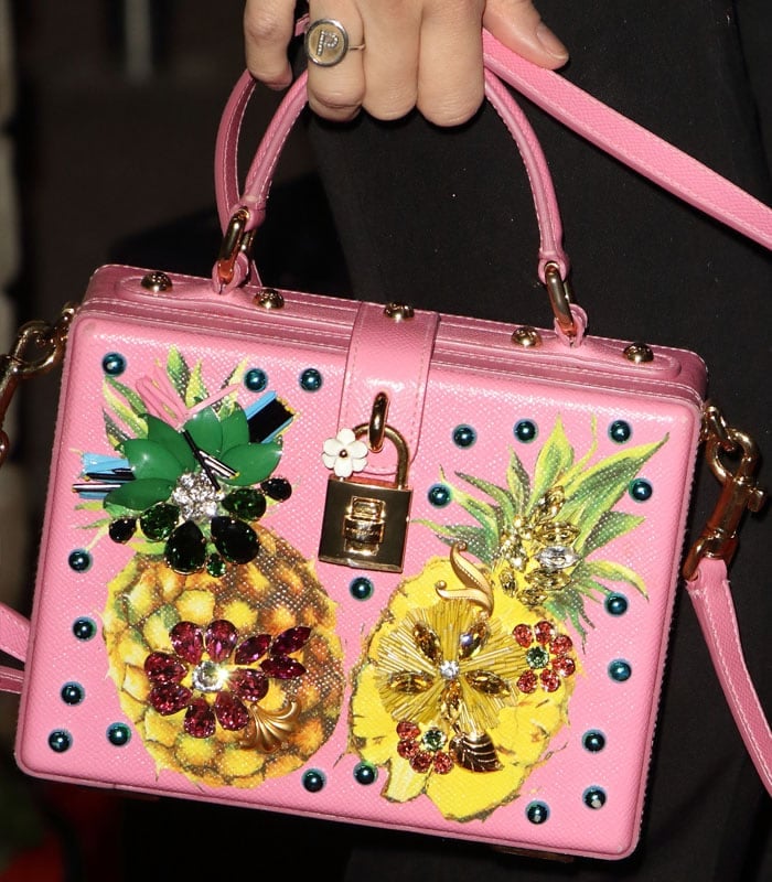 Close-up of Pixie Lott's pink Dolce Gabbana box handbag, embellished with jeweled pineapples, 3D floral appliqués, and signature gold-tone hardware