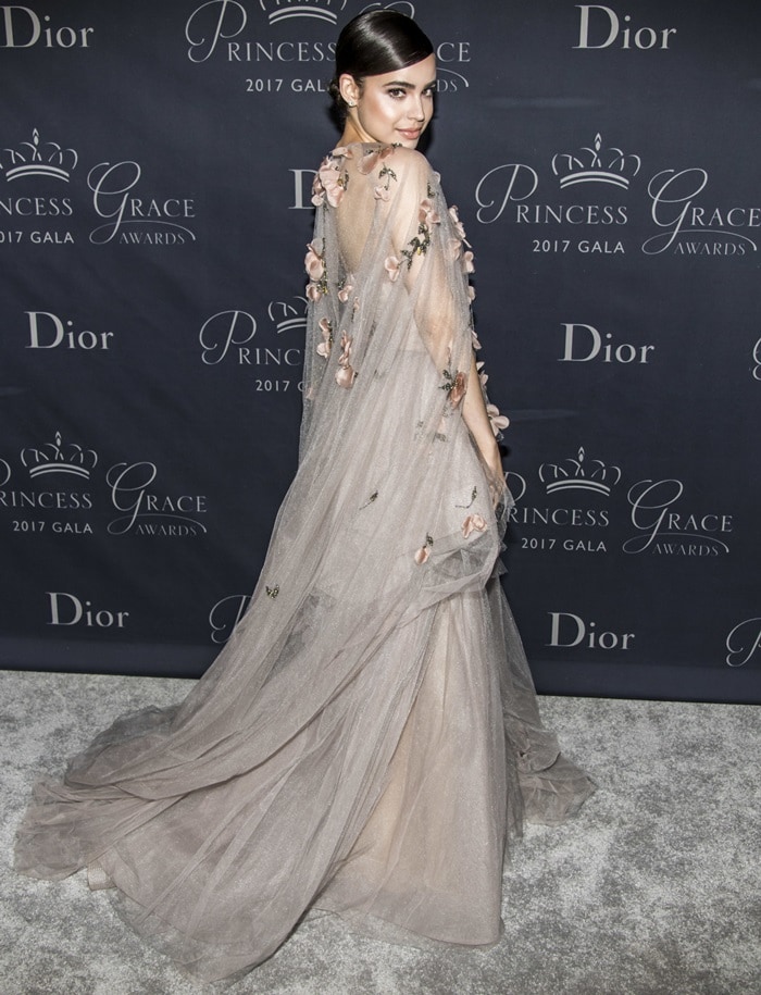Sofia Carson turns to reveal the gown’s cascading train and gauzy embroidered cape, the floor-length silhouette hiding whatever sparkling stilettos she almost certainly wore beneath it at The 2017 Princess Grace Awards Gala