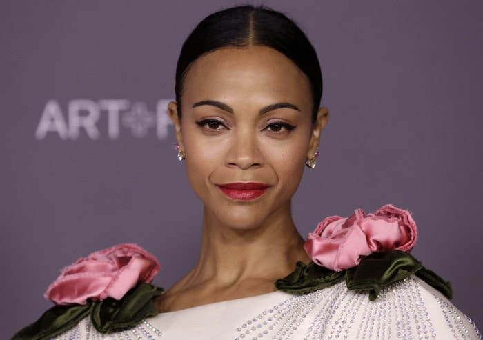 Zoe Saldaña showcases sleek glam with a polished updo and bold red lip, highlighting the sculptural floral details on her Gucci gown