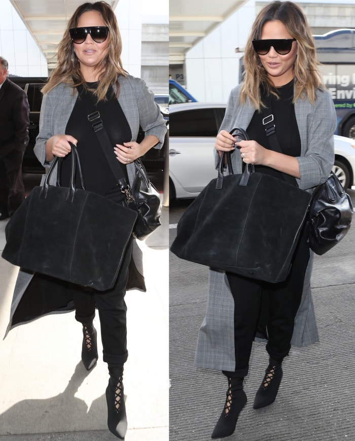 Chrissy Teigen elevates her airport look with Yeezy Season 5 lace-up boots, letting the sleek pointed-toe silhouette sharpen a layered ensemble of an Alice + Olivia long coat, black essentials, and luxe travel accessories