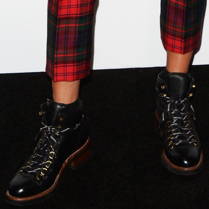 A closer look at Ruby’s black leather combat boots reveals their rugged lace-up detailing, gold hardware, and stacked sole finish