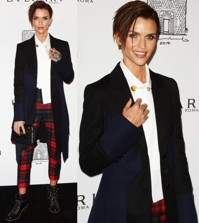 Ruby Rose shows off her edgy style in Burberry tartan trousers, a crisp white shirt, and a navy trench coat, grounding the look with lace-up combat boots