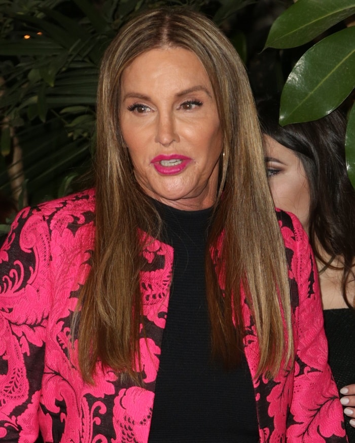 Caitlyn Jenner arrives at the GQ Men of the Year Dinner in Los Angeles wearing a vivid hot pink patterned jacket layered over a streamlined black dress